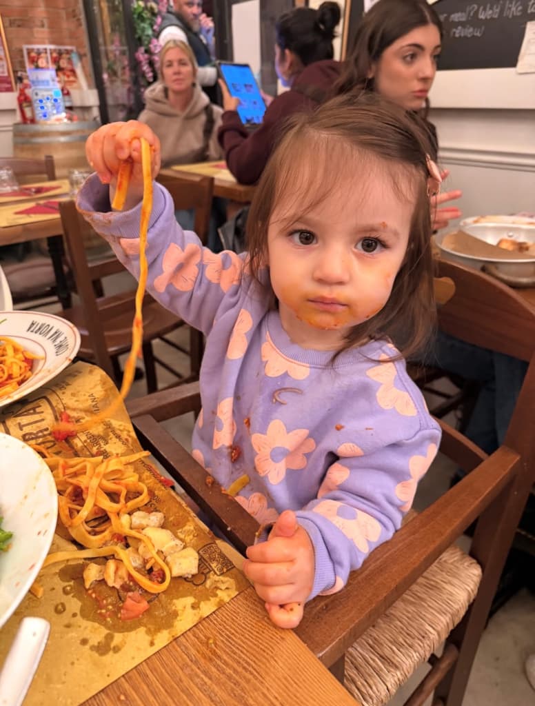 My daughter enjoying pasta at a restaurant
